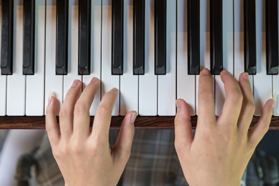 Hands at piano keyboard